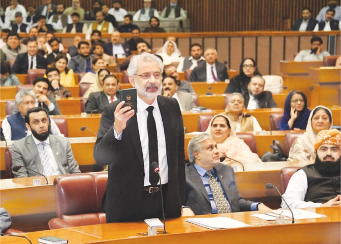  Justice Qazi Faez Isa, senior puisne judge of the Supreme Court, holds up a copy of the Constitution during his address.—Facebook / National Assembly 